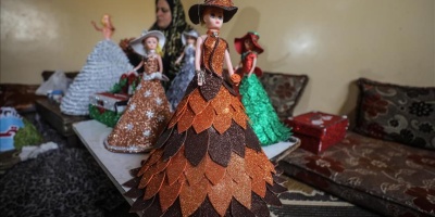 Filistinli Hena oyuncak bebekleri renkli kartonlarla giydiriyor